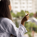 woman in spa robe on a balcony drinking champagne (glow getter)