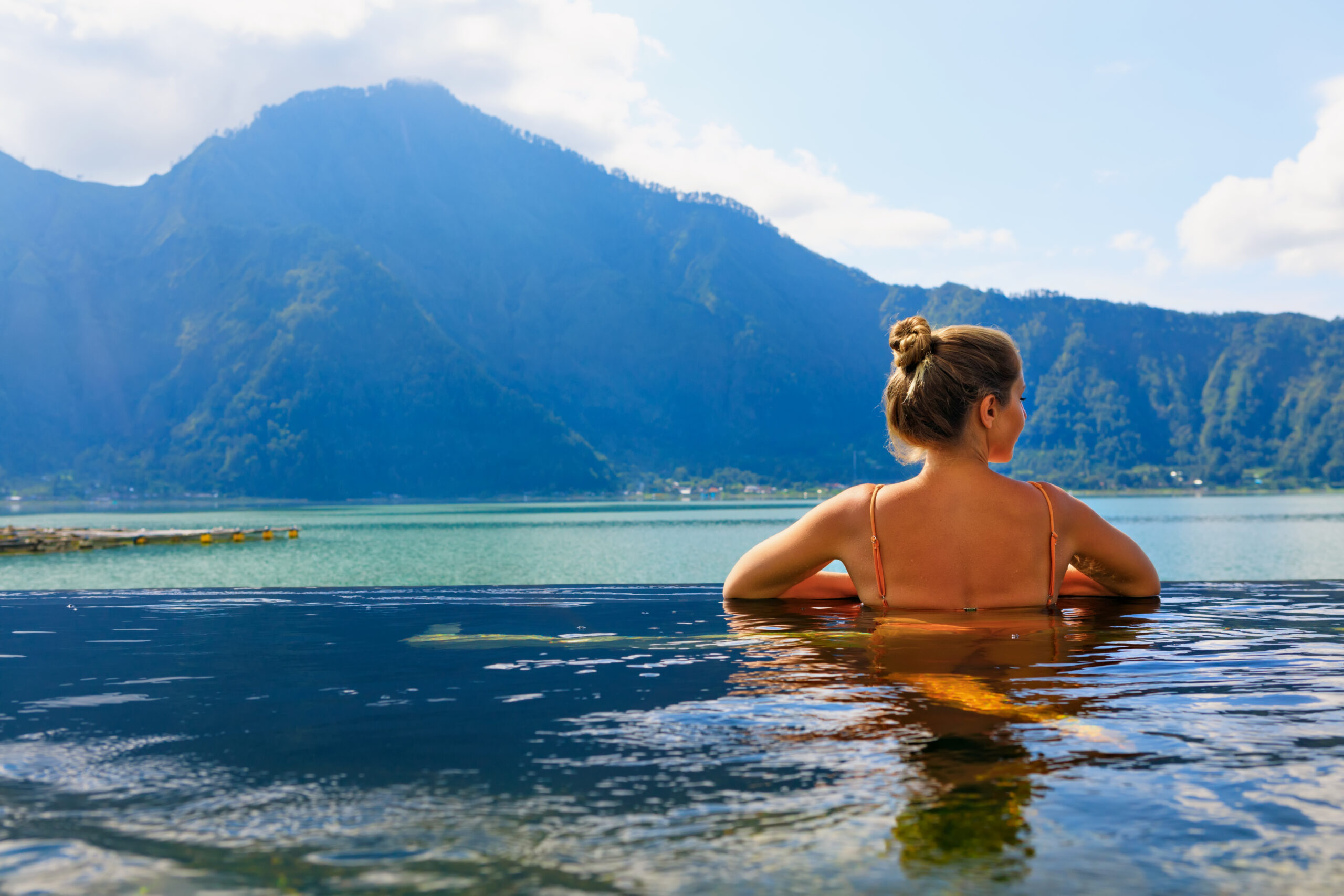 Young,Woman,Relax,Infinity,Pool,With,Lake,View.,Natural